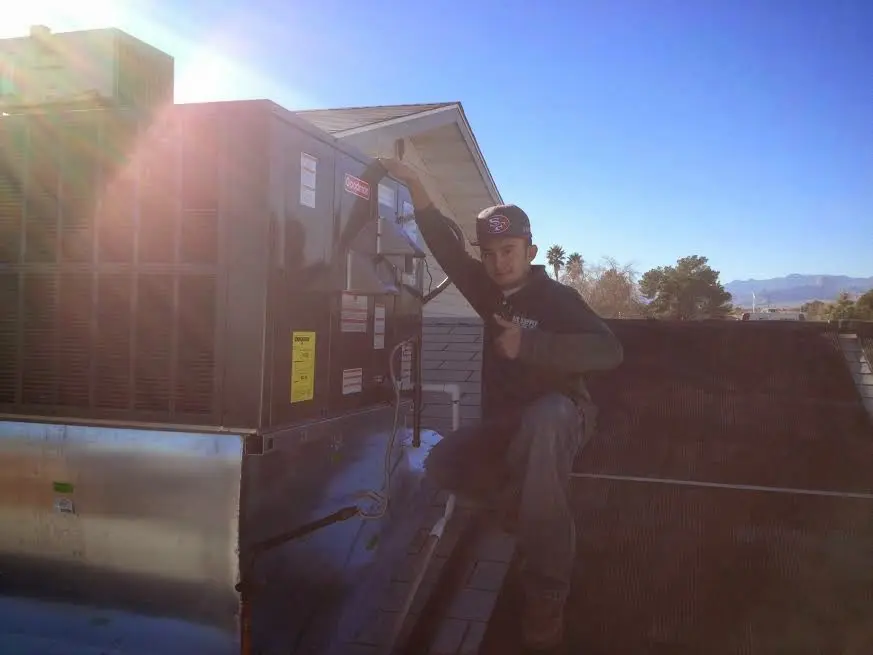 HVAC technician performing Boiler Repair on a rooftop unit in Manchester